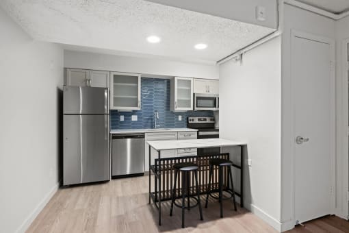 a kitchen with a island and a stainless steel refrigerator at AVIA Lofts on Liberty Ridge, Jacksonville, FL