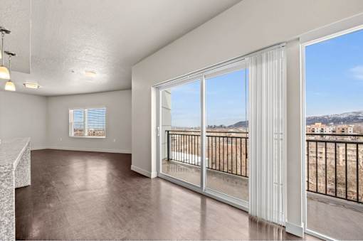 a living room with a large window and a balcony at Wilmington Flats Apartments, Salt Lake City, Utah