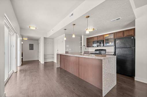 a kitchen with an island and a black refrigerator at Wilmington Flats Apartments, Salt Lake City, Utah