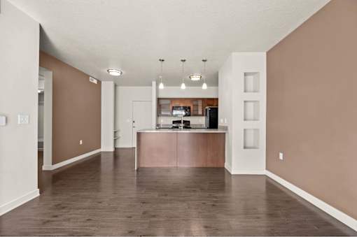 an empty living room with a kitchen in the background at Wilmington Flats Apartments, Salt Lake City, UT