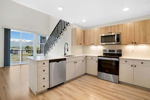 A modern kitchen with wooden cabinets and stainless steel appliances.
