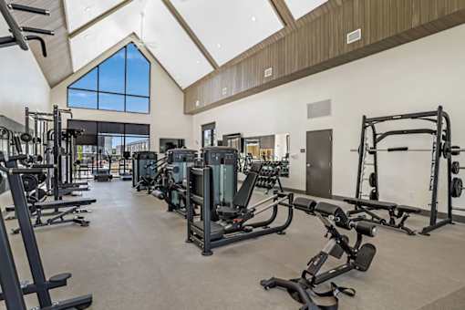 A spacious gym with a variety of equipment and a skylight.