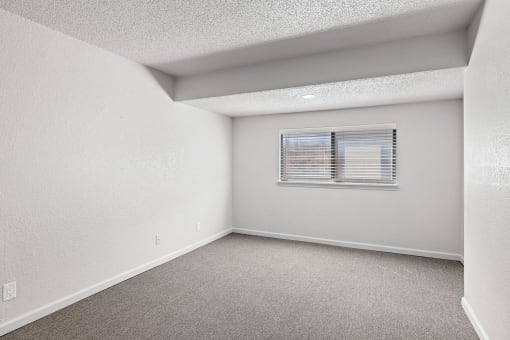 an empty room with white walls and a window