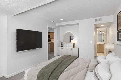 a bedroom with a large bed and a tv on the wall