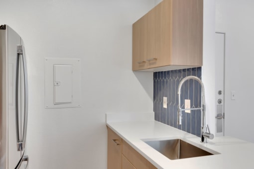 a white kitchen with a sink and a refrigerator