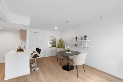 a dining area with a table and chairs and a kitchen