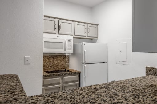 a kitchen with granite counter tops and white appliances