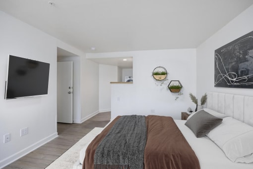 a bedroom with a bed and a television on the wall
