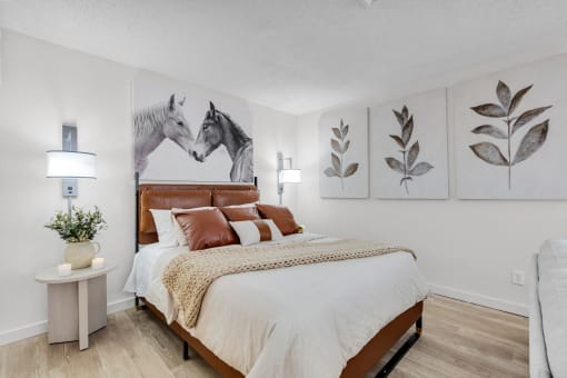 a bedroom with a bed and paintings of horses at AVIA Lofts on Liberty Ridge, Florida, 32256