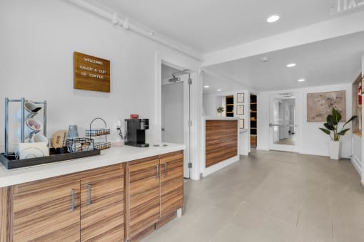 a kitchen with white walls and wooden cabinets and a white counter top at AVIA Lofts on Liberty Ridge, Jacksonville, FL