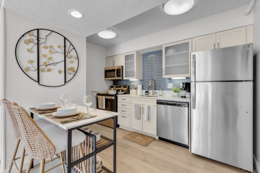 a kitchen with stainless steel appliances and a table with chairs at AVIA Lofts on Liberty Ridge, Jacksonville, FL