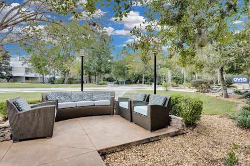 a patio with couches and chairs and trees at AVIA Lofts on Liberty Ridge, Florida, 32256