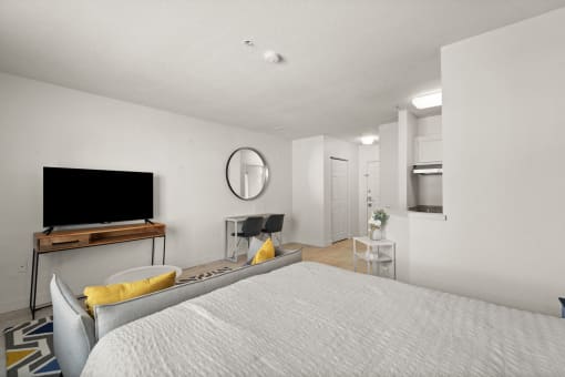 a bedroom with a bed and a desk and a television
