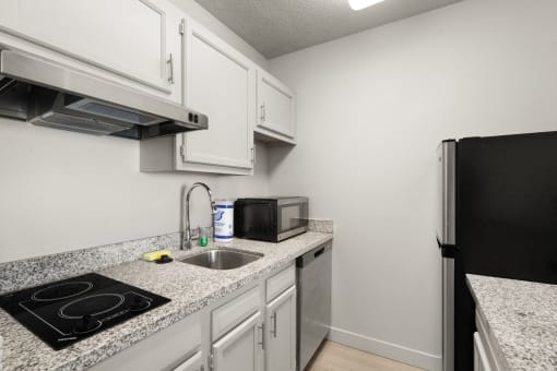 the kitchen of our studio apartment atrium with granite counter tops and white cabinets