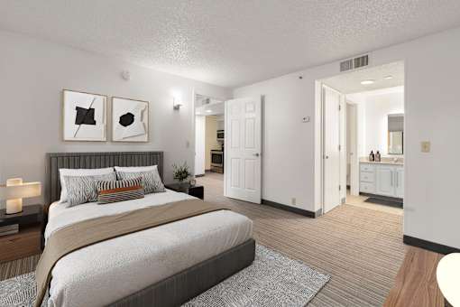 A bedroom with a large bed and a nightstand with a lamp.