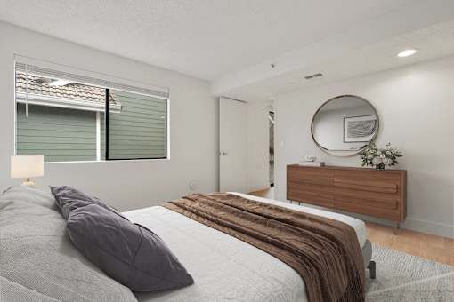 A bedroom with a bed, a dresser, and a mirror.