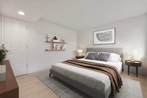 A bedroom with a bed, nightstands, and a plant.