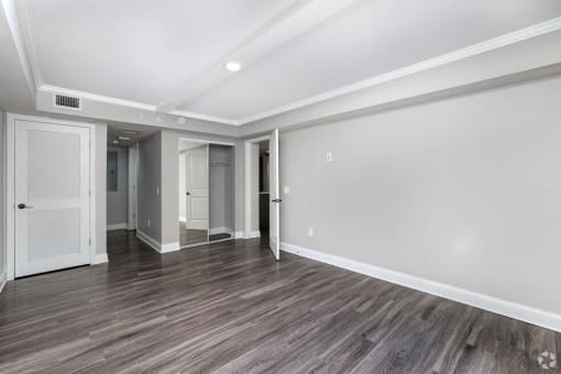 the living room of a new home with white walls and wood floors