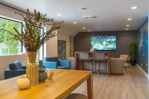 a room with a table and chairs and a tv on the wall
