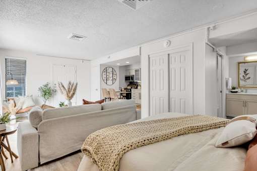 a bedroom with a bed and a living room with a couch at AVIA Lofts on Liberty Ridge, Florida, 32256