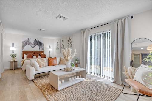 a living room with a couch and a sliding glass door to a bedroom at AVIA Lofts on Liberty Ridge, Florida