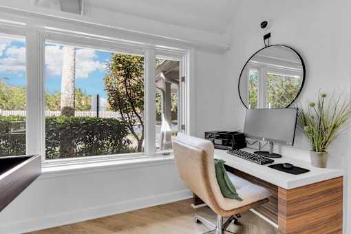 a home office with a large window and a desk with a computer at AVIA Lofts on Liberty Ridge, Florida, 32256