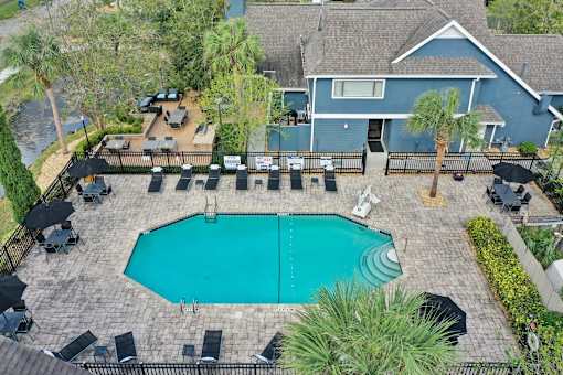 an aerial view of a swimming pool with a house in the background at AVIA Lofts on Liberty Ridge, Jacksonville, FL