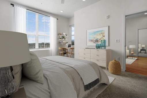A bedroom with a large bed, a painting on the wall, and a wooden floor.