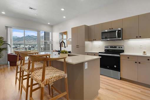 A kitchen with wooden chairs and a counter.