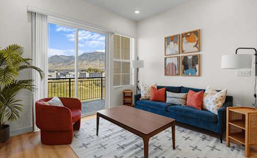 A living room with a blue couch and a red chair.