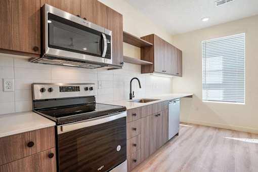 A modern kitchen with a stove, microwave, and sink.