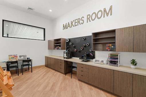 A makers room with a table, chairs, and a cabinet with tools.