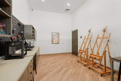 A room with wooden floors and a white wall with a door and a picture on it.