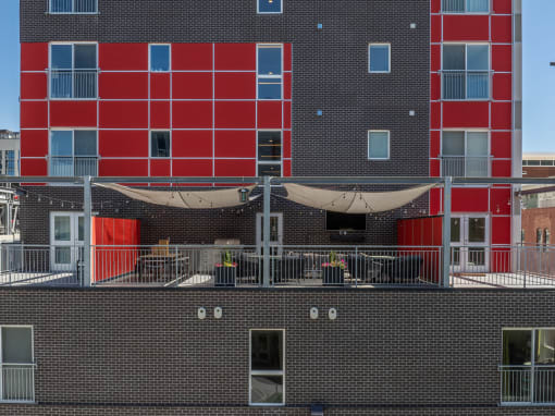 the back of a brick building with red doors and a balcony at Paperbox Lofts, Utah, 84101