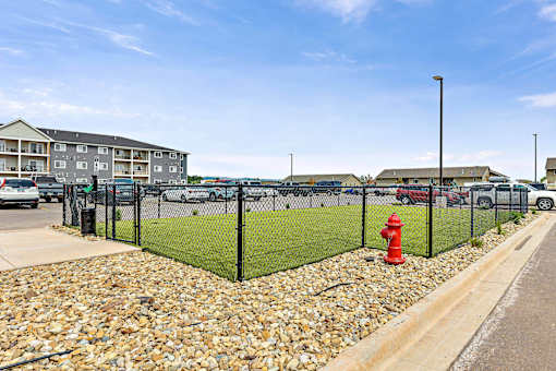 a view of a dog park with a red fire hydrant in front at Red Rock Apartments, Rapid City, 57702