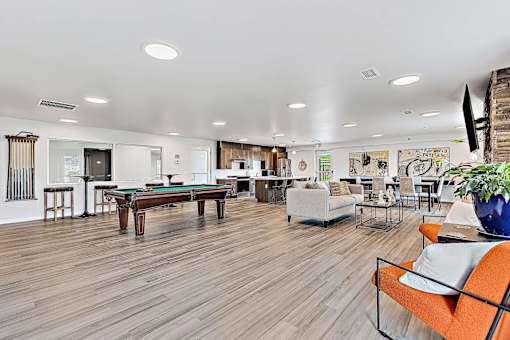 A living room with a pool table and a couch.
