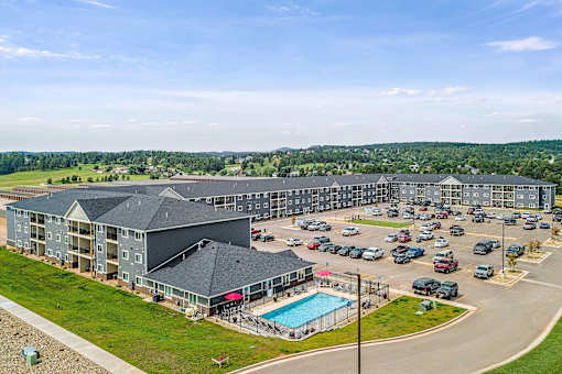 a large apartment complex with a swimming pool and parking lotv