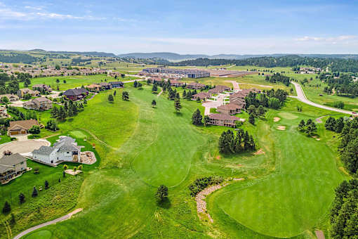 arial view of a golf course with houses in the background at Red Rock Apartments, South Dakota