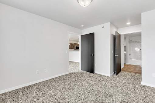 a bedroom with grey carpet and white walls at Red Rock Apartments, Rapid City, SD