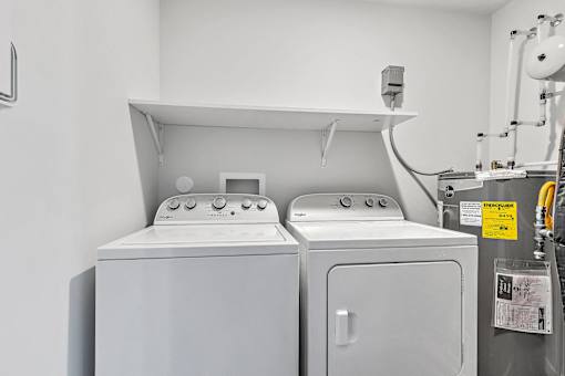 Two white washing machines in a laundry room.