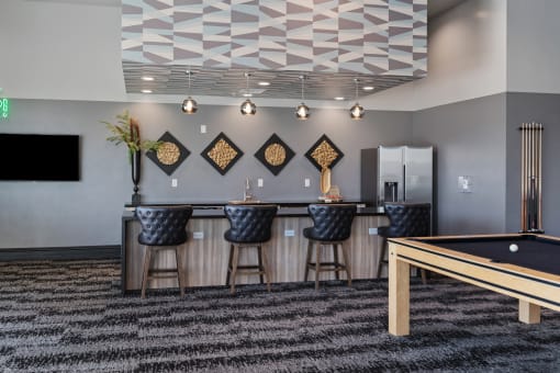 a clubhouse with a pool table and a bar with bar stools at SevenO2 Main Apartments, Salt Lake City, Utah