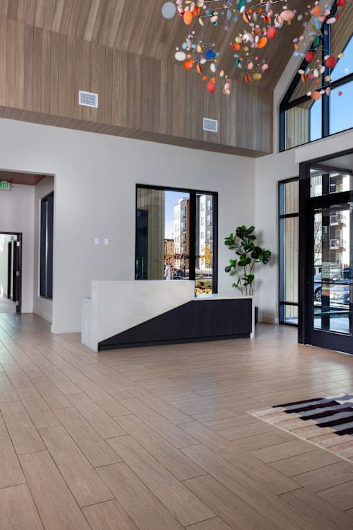A reception area with a white counter and a plant on it at Solhavn Apartments, American Fork, UT