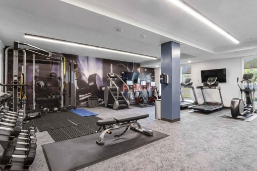 a spacious fitness room with cardio equipment and a flat screen tv at The Flats at Riverwoods, Utah, 84604