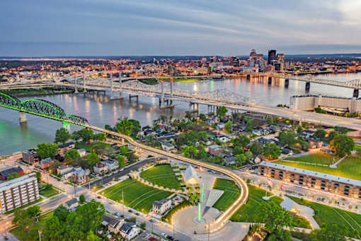 A cityscape with a river and a bridge in the background.