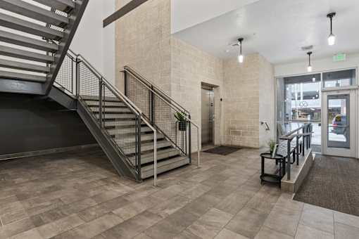 A staircase with a metal railing and a black handrail. at Wilmington Flats Apartments, Salt Lake City, 84106