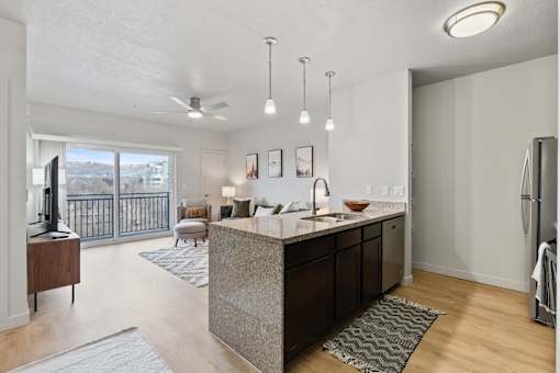 A modern kitchen with a large island and a view of the city. at Wilmington Flats Apartments, Salt Lake City