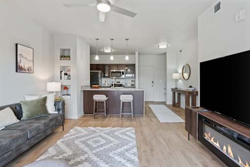 A modern living room with a grey couch and a fireplace at Wilmington Flats Apartments, Salt Lake City