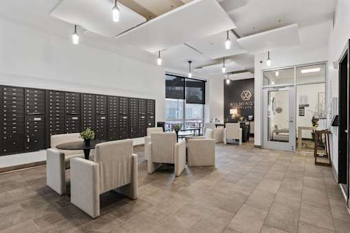 A modern waiting room with beige chairs and a black board on the wall at Wilmington Flats Apartments, Salt Lake City, Utah