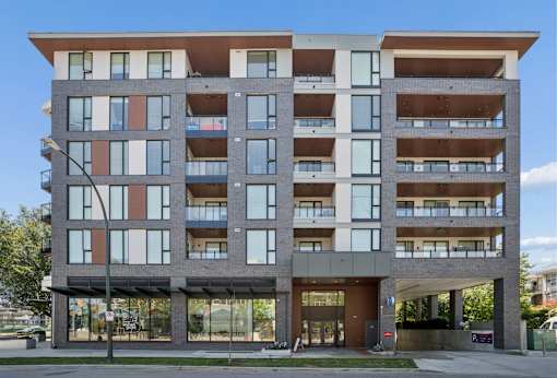 A modern multi-story building with balconies and large windows.