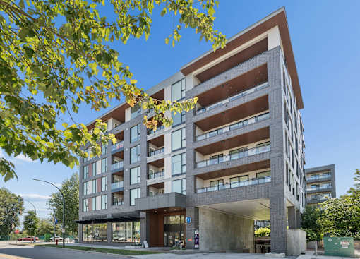 A modern multi-story building with a parking garage underneath.
